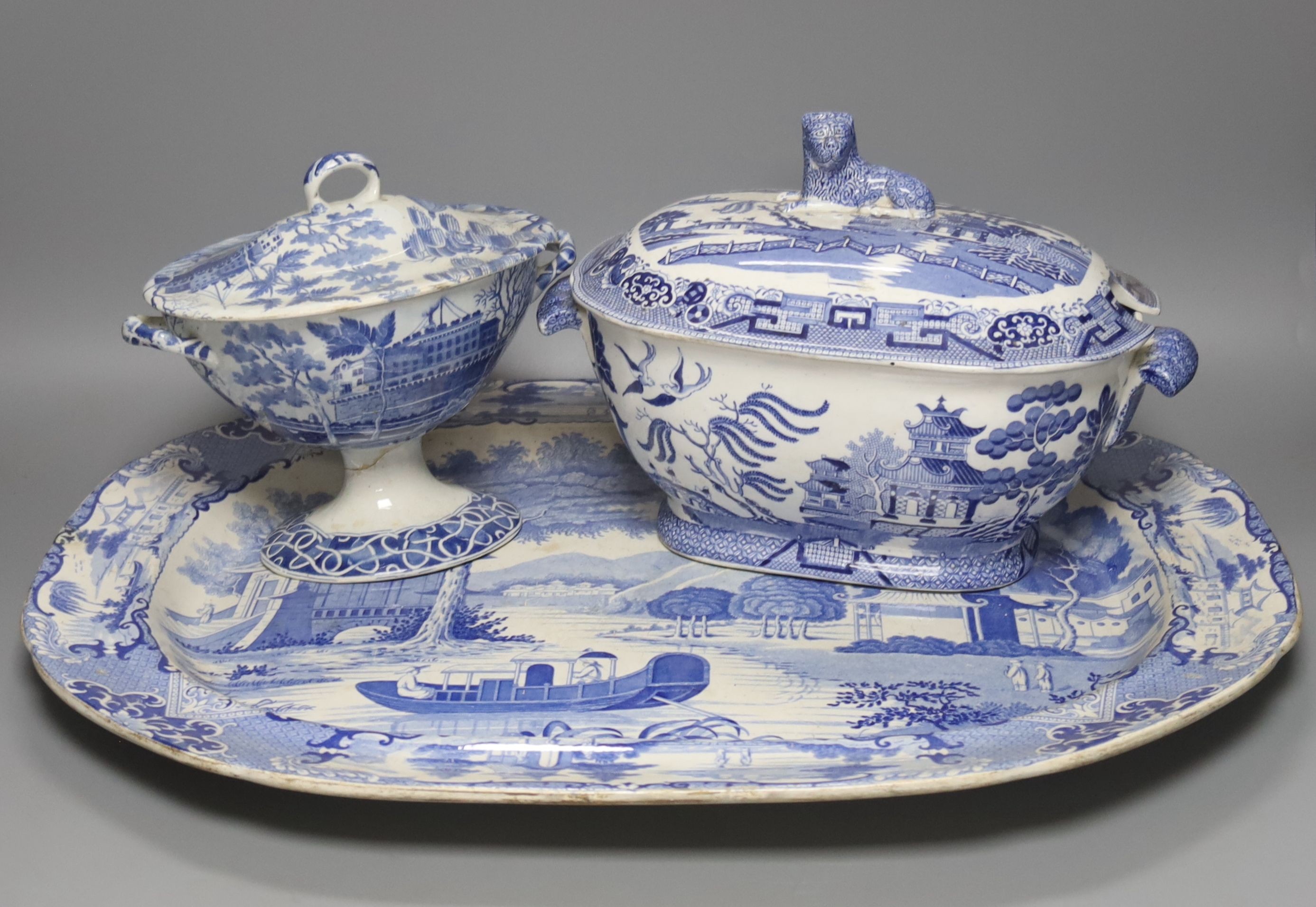 A group of 19th century blue and white pottery to include a chinoiserie pattern meat plate, 53.5 cm, a patent ironstone pheasant pattern dish, 47.5 cm, various tureens, dishes, ladles etc. a pearlware jug and two Chinese